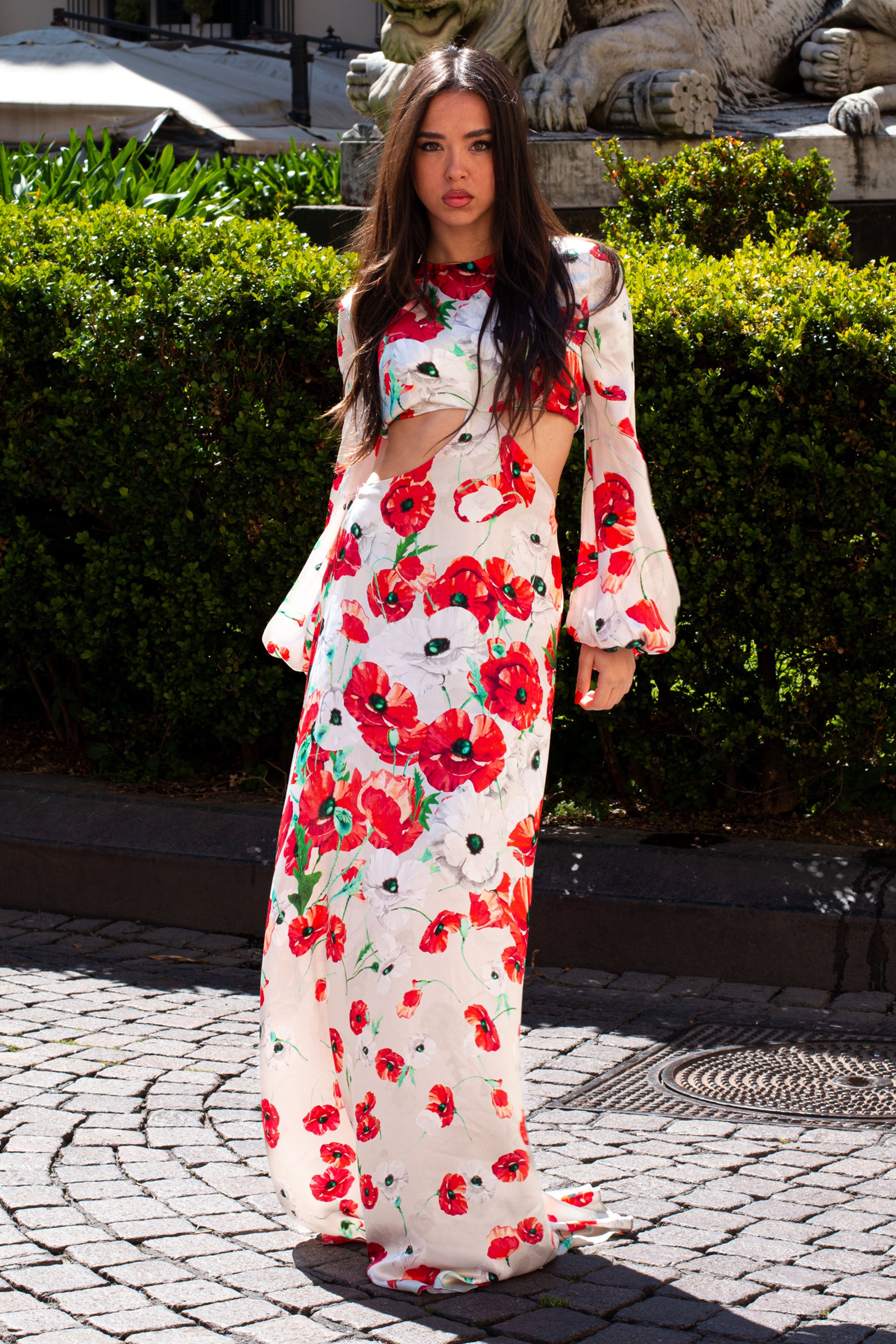 Modella che indossa Fiona Long Dress di Raquel Diniz in satin di seta con stampa floreale rossa e grigia, abito lungo Made in Italy