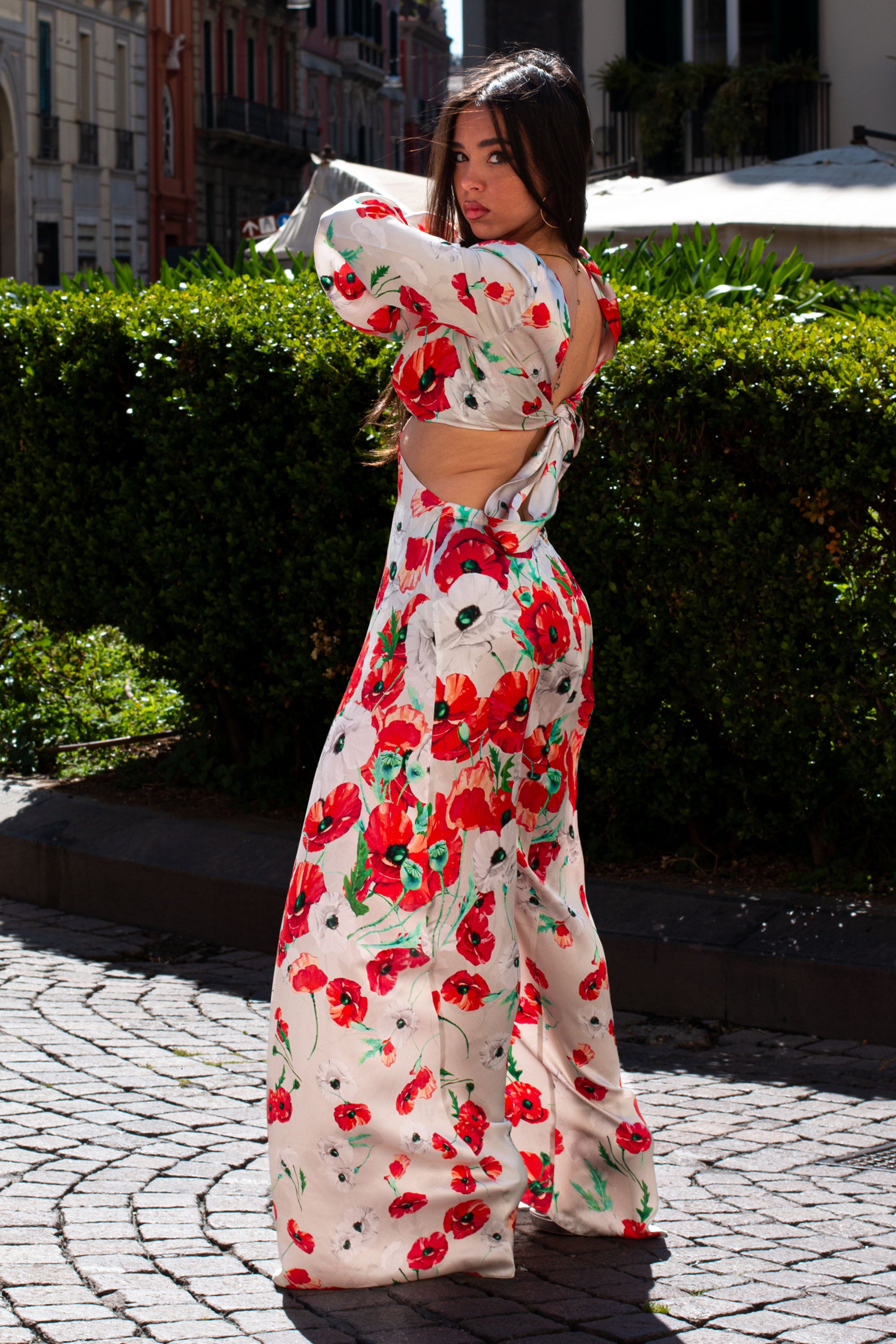 Vista laterale del Fiona Long Dress Raquel Diniz con apertura laterale e schiena scoperta, fantasia floreale rossa e bianca