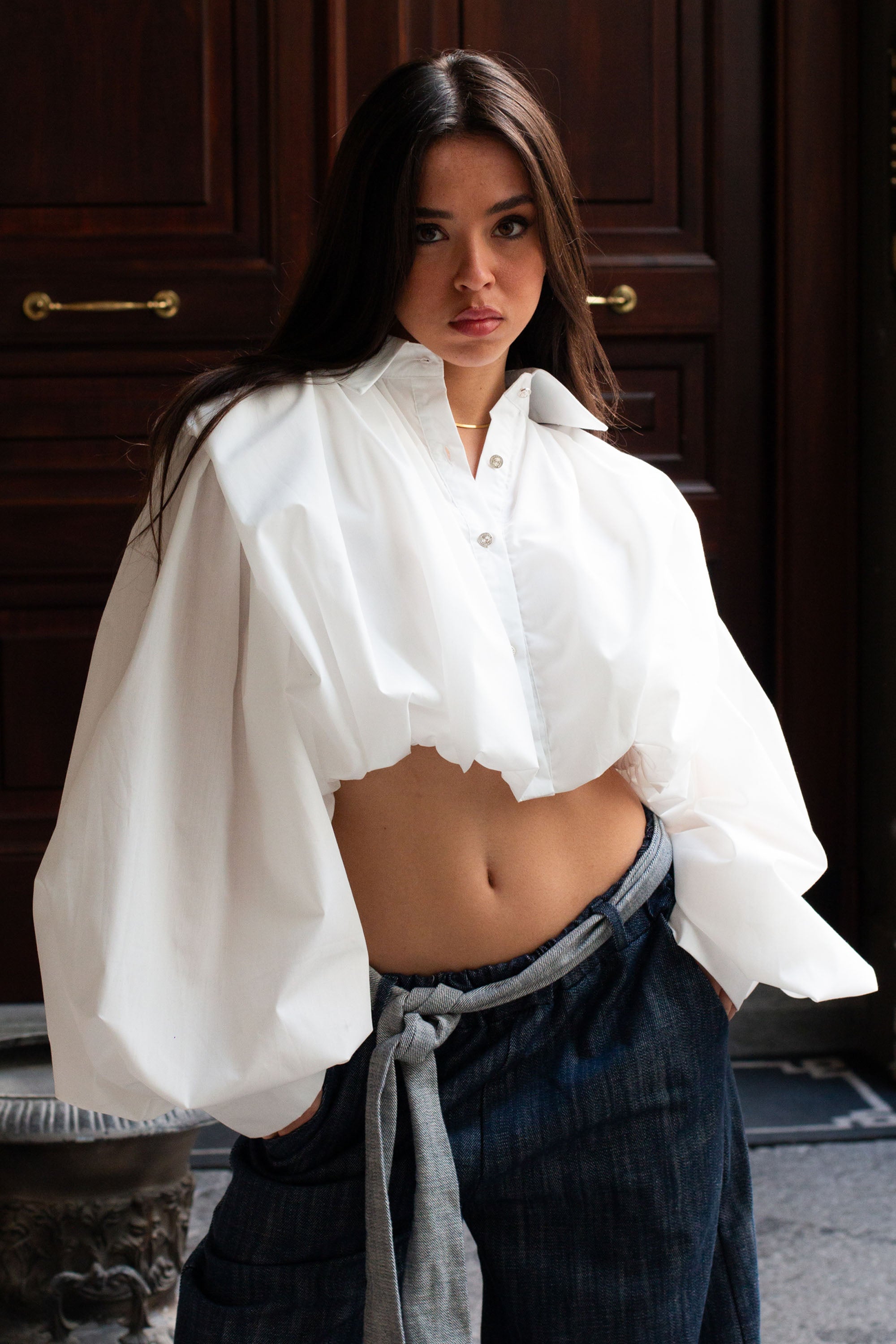 Modella che indossa Camicia Lara di Mangano in cotone bianco, Made in Italy, stile elegante primaverile