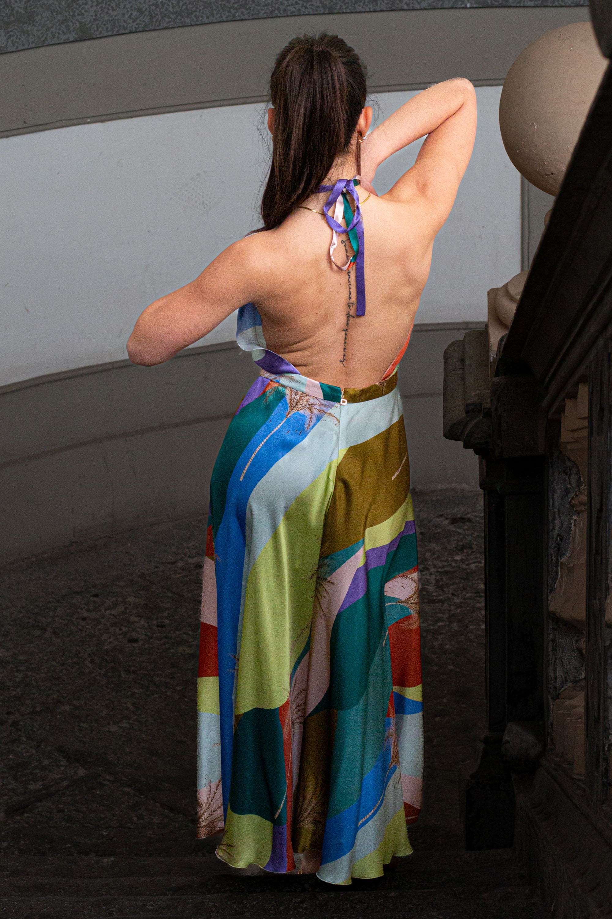 Vista posteriore del Giovanna Midi Dress di Raquel Diniz in satin di seta, stampa sunset colorata, schiena scoperta e nodo al collo