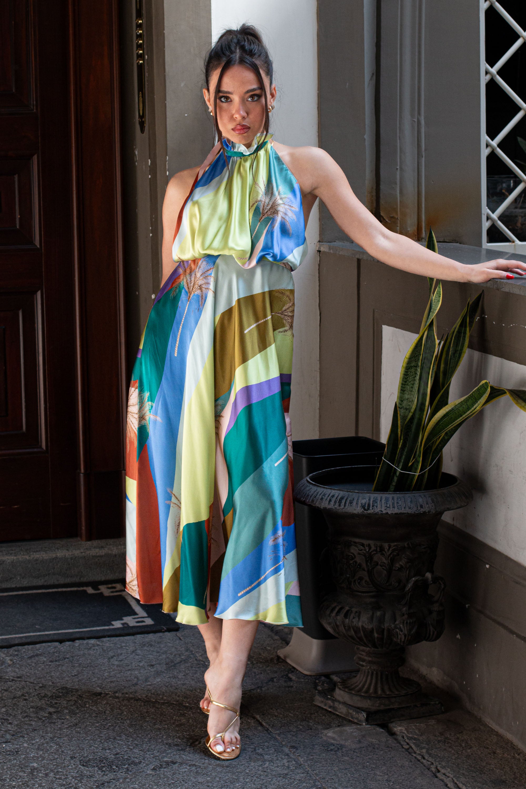 Modella in posa con abito midi colorato Giovanna di Raquel Diniz, dettaglio di tessuto in satin con stampa sunset